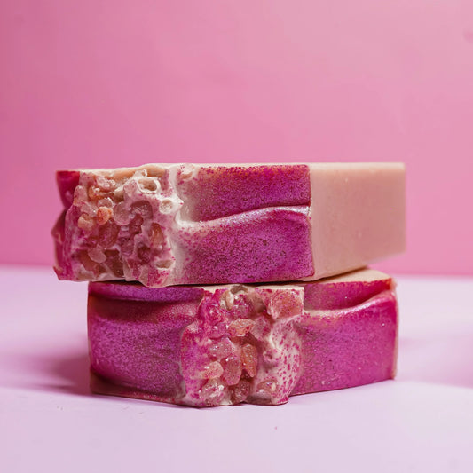Handcrafted pink sea salt soap bars with textured tops on a pastel pink background