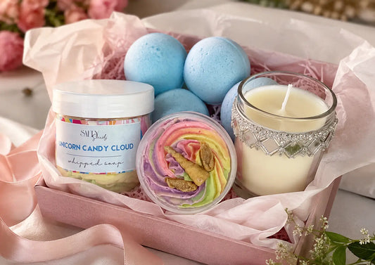 Salty Secrets self-care gift hamper with whipped soap, blue bath bombs and decorative candle arranged in a pink gift box.